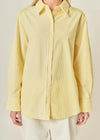 Person wearing a yellow striped shirt against a beige background