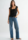 Woman wearing a black top and blue jeans on a white background
