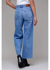 Person wearing blue jeans on a plain background