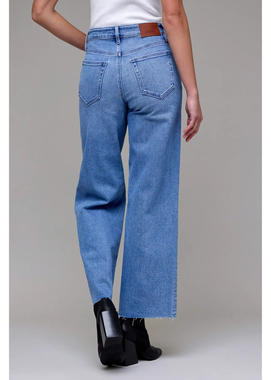 Person wearing blue jeans on a plain background