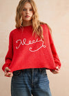 Person wearing a red sweater with white text on a beige background