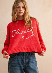  Person wearing a red sweater with white text on a beige background
