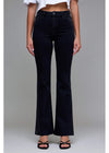 Person wearing black flared jeans on a plain background