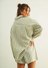 Woman wearing a green and white striped shirt against a plain background