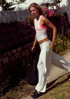 Woman in athletic wear walking outdoors near a fence and plants