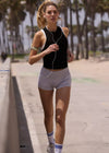 Woman running on a path with palm trees in the background