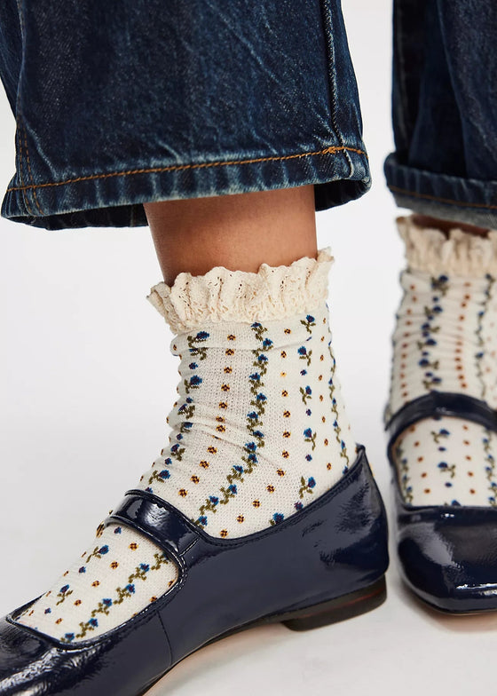 Navy shoes with white socks featuring blue and gold patterns on a light background