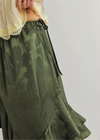 Green floral skirt with a white lace top on a plain background