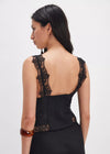 Black dress with lace detailing on a plain background