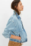 Light blue denim jacket worn by a person on a white background