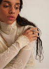 Woman wearing a white lace top with a plain background