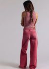 Person wearing a pink sleeveless top and pants on a plain background