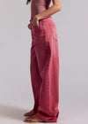 Person wearing pink pants and a striped top on a plain background