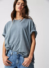 Person wearing a light blue oversized t-shirt and jeans on a white background