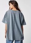 Woman wearing a gray oversized shirt and jeans on a white background