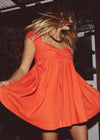 Woman in an orange dress with a blurred background