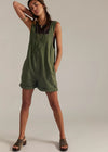 Woman wearing a green romper against a plain background