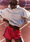 Person wearing a white hoodie and red shorts on a track