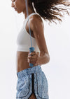 Person exercising with a jump rope on a plain background