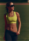 Woman in athletic wear standing outdoors with a blurred background