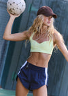 Woman in athletic wear holding a soccer ball outdoors