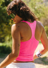 Person wearing a pink tank top with visible tattoos outdoors