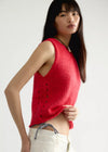 Woman wearing a red knitted sleeveless top on a white background