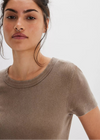 Woman wearing a brown t-shirt against a plain background