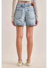 Light blue denim shorts worn by a person on a plain background