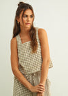 Woman wearing a checkered outfit against a plain background