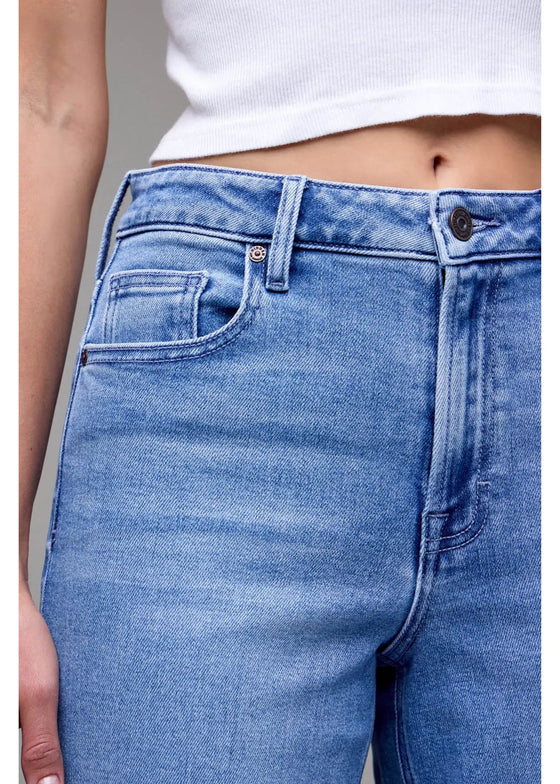 Close-up of blue jeans worn by a person with a neutral background