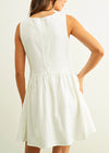 Woman wearing a white dress against a plain background
