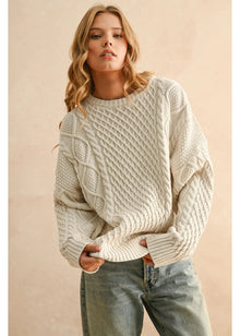  Woman wearing a beige cable knit sweater against a beige background