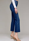 Person wearing blue jeans and a white top on a plain background