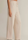 Beige linen pants worn by a person on a plain background