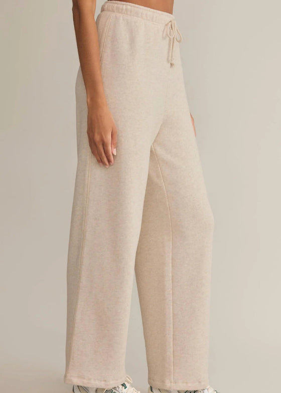 Beige linen pants worn by a person on a plain background