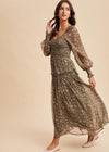 Woman wearing a long, patterned dress against a beige background