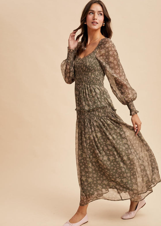 Woman wearing a long, patterned dress against a beige background