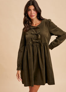  Woman wearing an olive green dress with long sleeves on a beige background