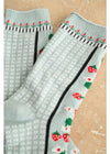 Light blue socks with black and red floral patterns on a beige background