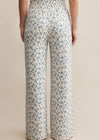 Floral-patterned pants worn by a person on a beige background