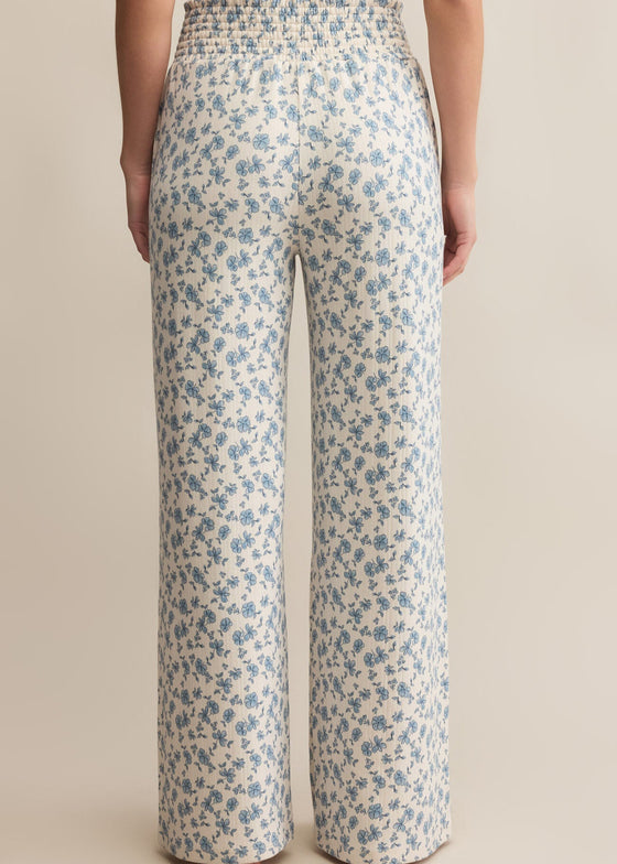Floral-patterned pants worn by a person on a beige background