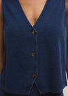 Blue sleeveless button-up garment on a neutral background