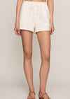 White lace shorts worn by a person on a plain background