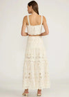 Woman wearing a white lace dress on a plain background