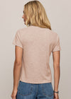 Woman wearing a beige t-shirt and blue jeans against a plain background
