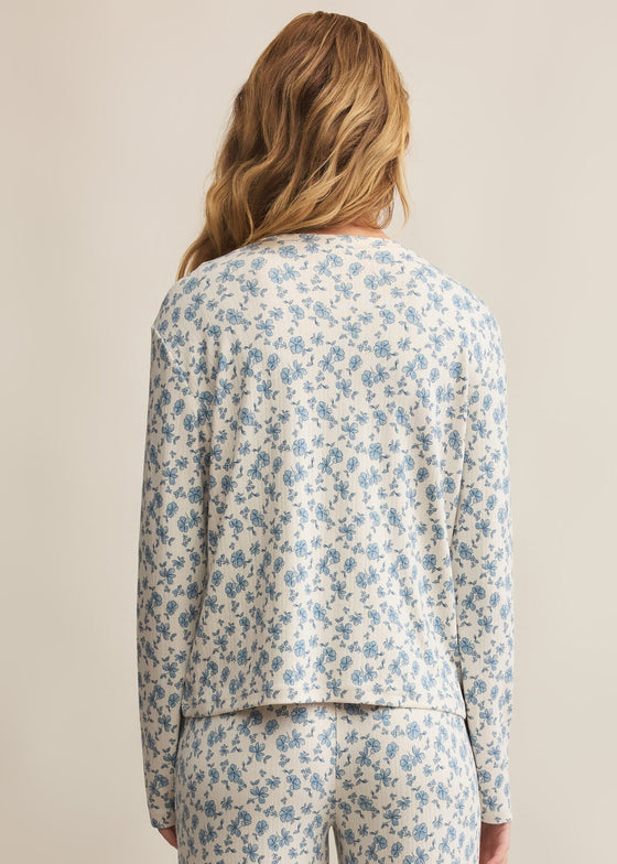 Person wearing a floral pajama set on a beige background