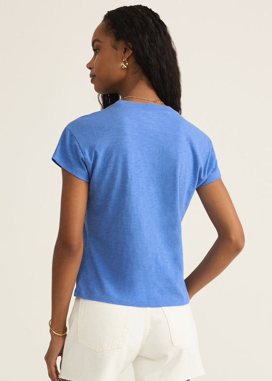 Woman wearing a blue t-shirt and white shorts on a beige background