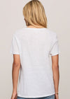 Person wearing a plain white t-shirt and blue jeans on a beige background