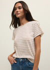 Woman wearing a striped shirt and blue jeans against a plain background